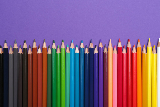 Colorful pencils on purple background, flat lay - Foto, Imagem