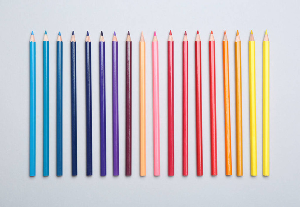 Colorful pencils on light background, flat lay - Foto, afbeelding