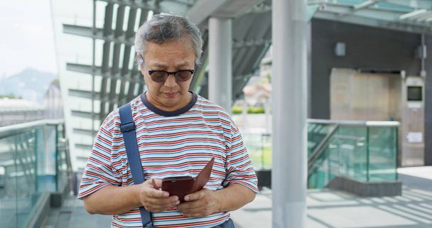 Asiático homem velho uso de telefone celular na cidade
 - Foto, Imagem