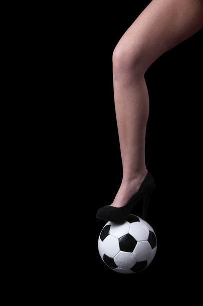 γυναίκα πόδι στο παπούτσι σταθεί σε μπάλα ποδοσφαίρου - Φωτογραφία, εικόνα