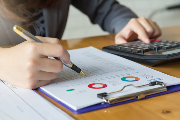 Üzleti és pénzügyi koncepció irodai munka, Üzletasszony segítségével számológép és a gazdaság toll megvitatására Havi költségvetési diagram - Fotó, kép