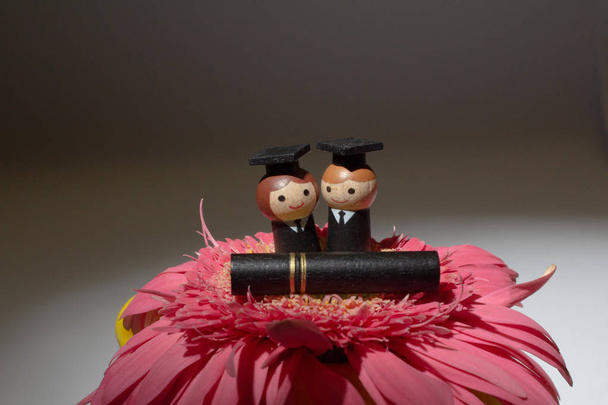 a mini of Happy graduates are standing on flower - Photo, Image
