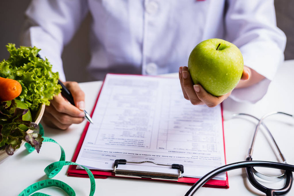 Táplálkozási szakember egészséges gyümölcs-, zöldség- és mérőszalaggal wo - Fotó, kép