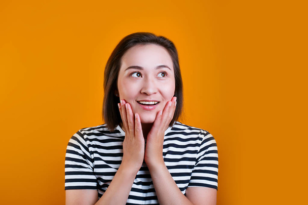 Portrait of excited asian woman isolated over yellow background - Photo, Image