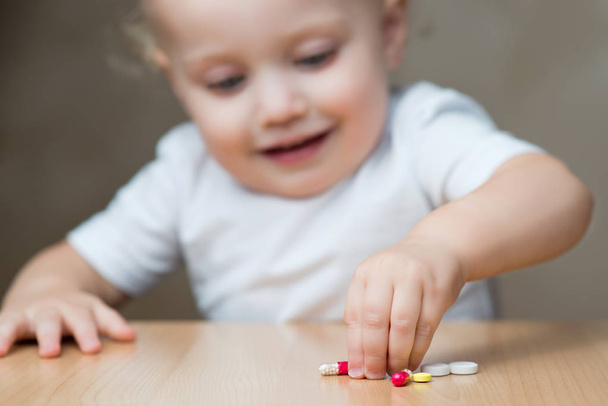 defocused little girl heading for pills left by adults, copy space - Photo, image