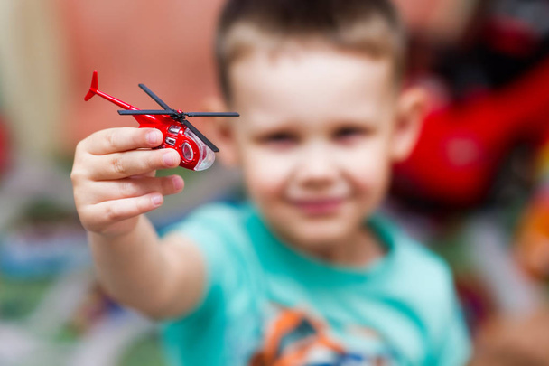 boy playing with a toy red helicopter - Foto, Bild