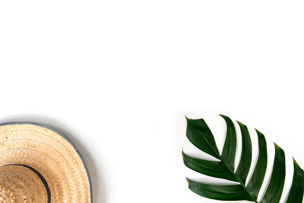 zielony liść tropikalny i słomkowy kapelusz na białym tle - Zdjęcie, obraz