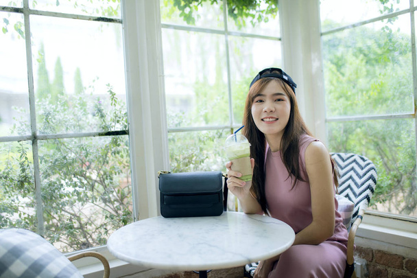 geluk lachend gezicht van Aziatische jongere vrouw met koele fles o - Foto, afbeelding