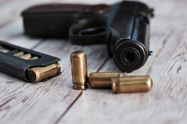 Gun with bullets on a wooden background. - Foto, Imagem