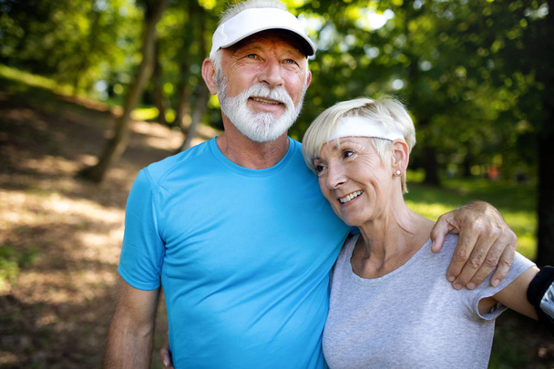 Active senior couple running in the park for healthy life - Foto, Imagen