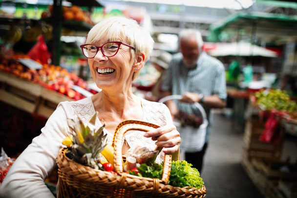 Senior woman buying vegetables at farmers market - Foto, immagini