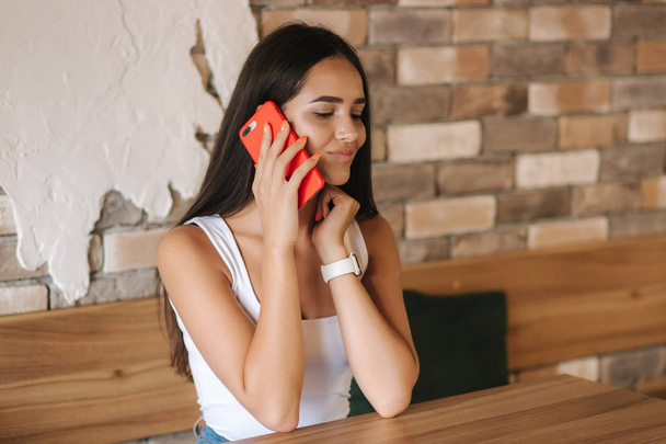 Piękna brunetka rozmawiająca przez telefon w kawiarni. Zamknij się kobieto korzystająca z telefonu - Zdjęcie, obraz
