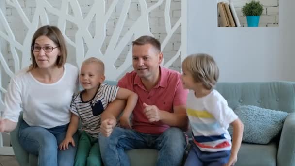 Excited family football fans watching tv, celebrating goal together - Video