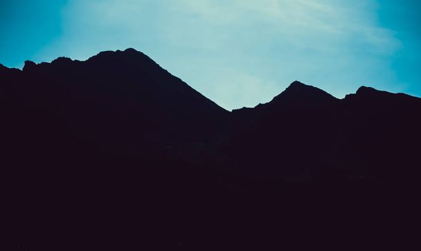 Vuorten ääriviivat sinisellä taivaalla maisema
 - Valokuva, kuva