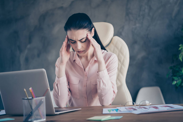 Low below angle view photo of exhausted ill hurt ceo sad unhappy upset with her head dizzy tired of paperwork and staring into screen willing to go on vacation - 写真・画像