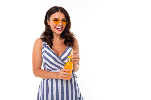 beautiful brunette girl drinking juice posing in studio  - Foto, Bild
