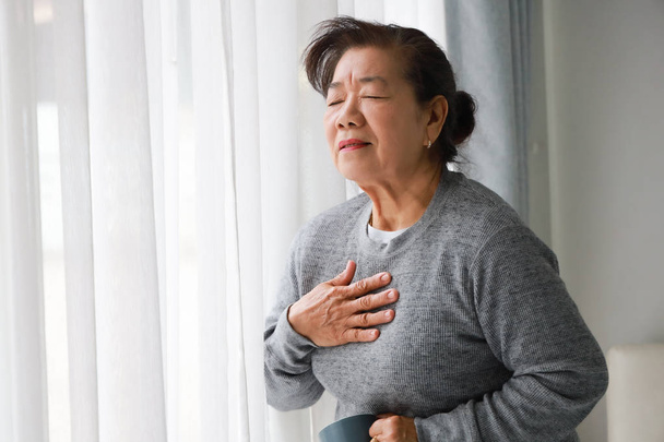 Asian senior woman mother sick with heart attact in living room  - Foto, Imagem