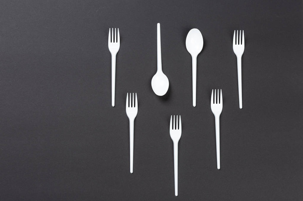 Horquillas y cucharas de plástico sobre fondo gris
 - Foto, imagen