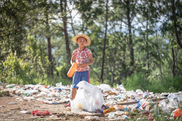 Un pobre chico recogiendo basura de un vertedero en el  - Foto, Imagen