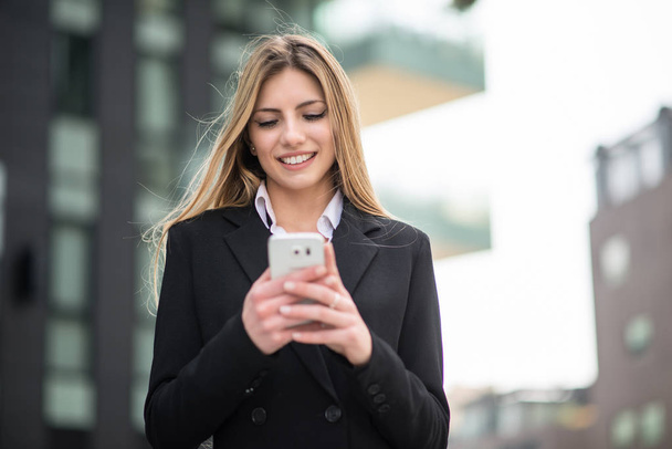 Business woman using her mobile phone - Foto, Imagen