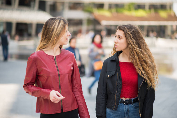 Happy friends talking while walking in a city - Zdjęcie, obraz