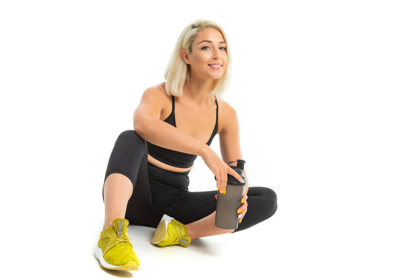 young beautiful blonde sportswoman posing in studio against white  - Фото, изображение