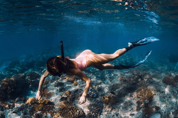 Slanke vrouw Freediver glijdt over bodem in onderwater - Foto, afbeelding