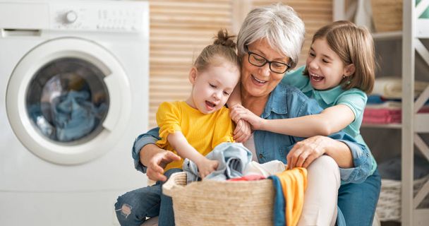 grandma and children are doing laundry - Photo, Image