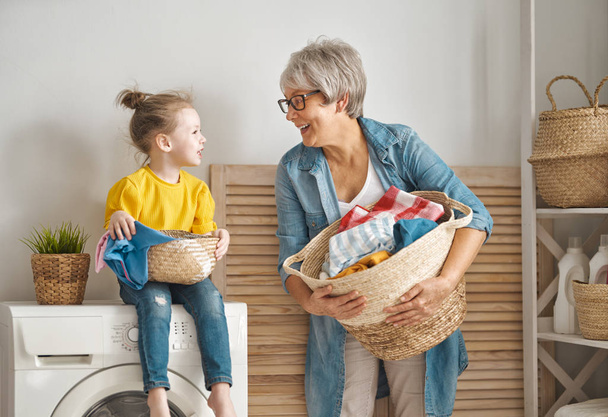 grandma and child are doing laundry - Photo, image