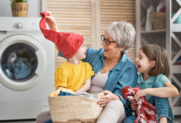 grandma and children are doing laundry - Фото, изображение