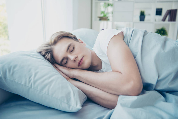 Close up photo of dreamy calm man guy lying on bed sleeping in night have free time want relax rest from difficult day in room indoors - Zdjęcie, obraz