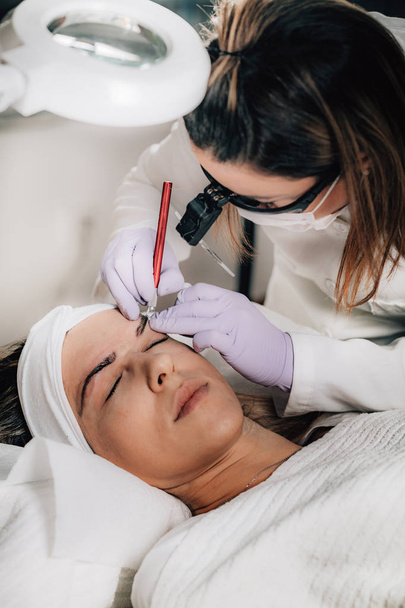 Brauen-Microblading-Verfahren zur Behandlung von Augenbrauen. professionelle Kosmetik - Foto, Bild