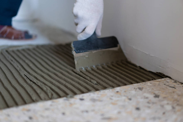 Riparazione e decorazione di appartamenti e case. Professionisti posare piastrelle di porcellana sul pavimento in bagno
. - Foto, immagini