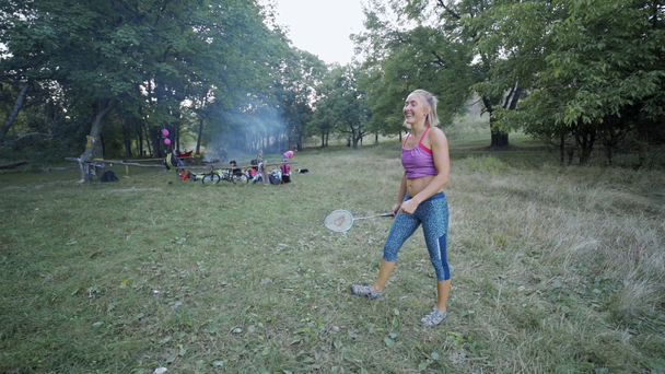 Csinos mosolygós sportos fitness nő játszik tollaslabda a parkban. - Felvétel, videó