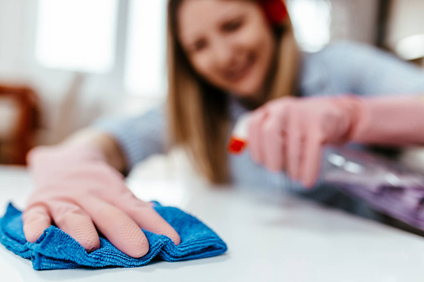 Kaunis nuori nainen puhdistaa talon mikrokuituliina. Taloudenpidon käsite
. - Valokuva, kuva