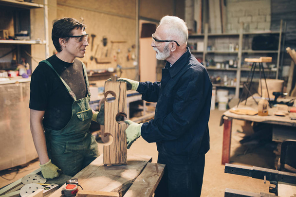 Deux maîtres charpentiers travaillant ensemble dans leur menuiserie ou atelier
.  - Photo, image
