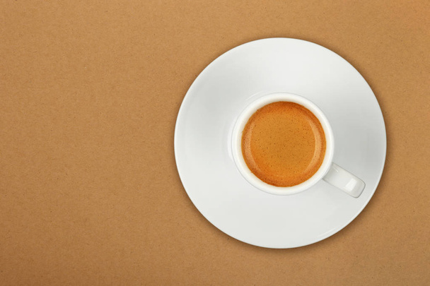 Повна біла чашка кави еспресо над коричневим
 - Фото, зображення