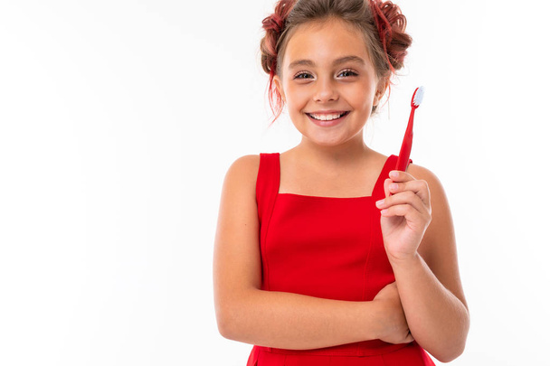 schattig klein meisje poseren met tandenborstel tegen witte achtergrond   - Foto, afbeelding