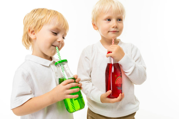 due bambini che bevono limonata, in posa su sfondo bianco - Foto, immagini