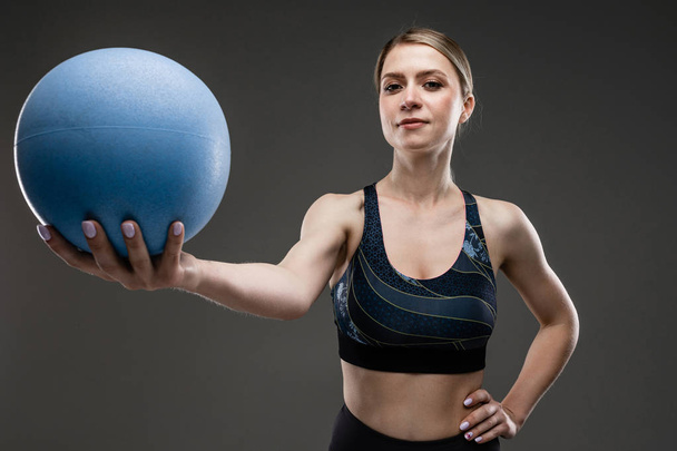 beautiful sportswoman posing against gray  - Photo, Image