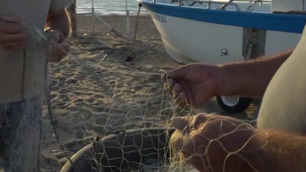 Fischer ziehen und reparieren die traditionellen Fischernetze von Hand - Filmmaterial, Video