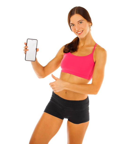Cheerful young fitness woman showing blank smartphone screen iso - 写真・画像