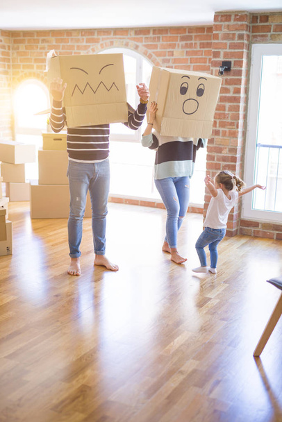 Belle famille avec enfant jouant avec des boîtes de fanny en carton à la nouvelle maison
 - Photo, image