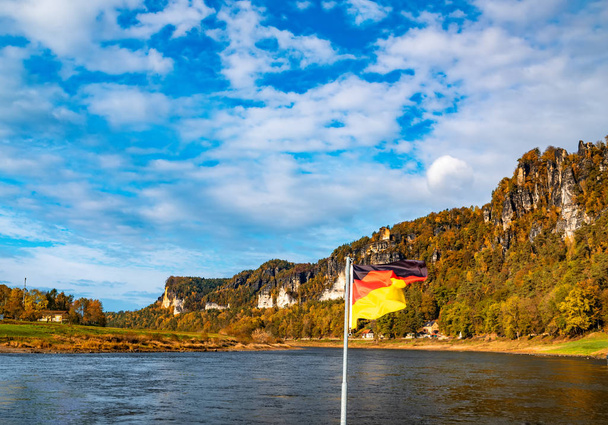 Нікчемний пейзаж на осінньому сяйві з Національним прапором Німеччини. Ельба (Саксонія, Німеччина). - Фото, зображення