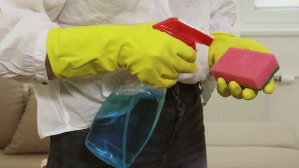 Donna in guanti e detergente spray a casa da vicino
 - Filmati, video