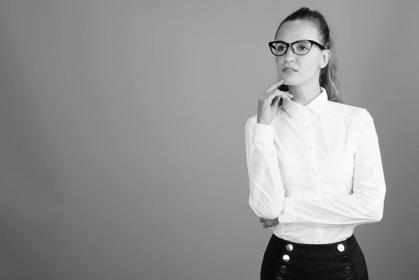 Portret van jonge mooie zakenvrouw denken geschoten in zwart-wit - Foto, afbeelding