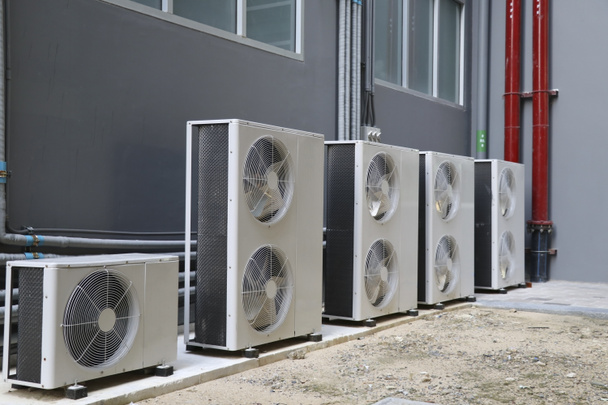 Condensing unit of air conditioning systems. Condensing unit installed in a row outside the building. - Photo, Image