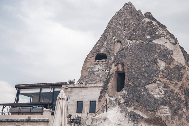 Barlang házak és épületek Cappadocia, Törökország. Kőcsúcsok nyílászárókkal. Valódi barlangok lakhelye. - Fotó, kép