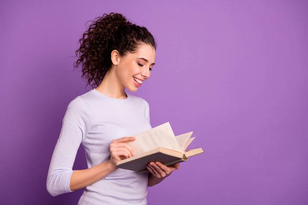 Photo of sweet cute girlfriend leafing through her book to learn new information holding hands isolated over purple pastel color background - Foto, imagen