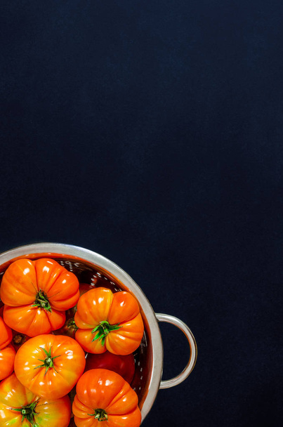 Siyah bir arka plan üzerinde bir kevgir çeşitli domates yıkanmış - Fotoğraf, Görsel